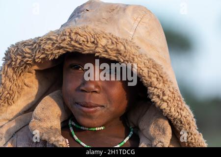 NAMIBIE, RÉGION D'OMUSATI, MAI 7: Fille africaine tôt le matin froid sur la route de la ville d'Opuwo. Namibie du Nord, 6 mai 2018, Namibie Afrique Banque D'Images