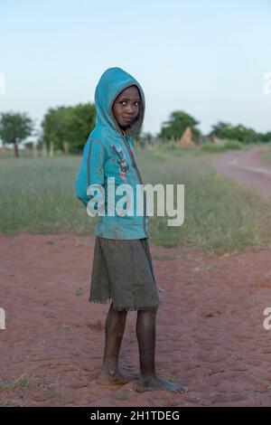 NAMIBIE, RÉGION D'OMUSATI, MAI 7: Fille africaine tôt le matin froid sur la route de la ville d'Opuwo. Namibie du Nord, 6 mai 2018, Namibie Afrique Banque D'Images