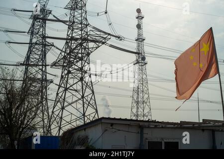 Drapeau chinois agitant devant les tours de transmission haute tension à Tianjin, en Chine.19 octobre 2021 Banque D'Images