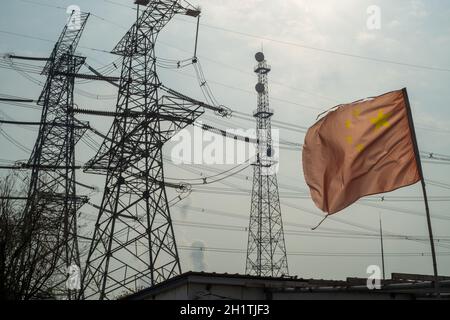 Drapeau chinois agitant devant les tours de transmission haute tension à Tianjin, en Chine.19 octobre 2021 Banque D'Images