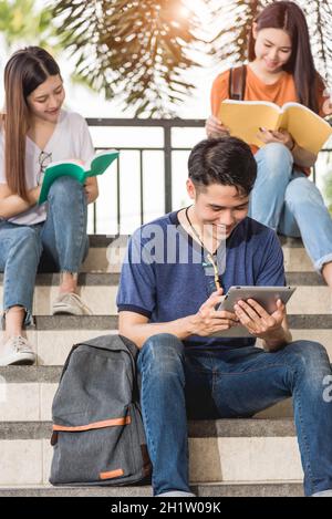 Les jeunes asiatiques heureux, hommes et femmes, ont l'intention de lire des livres à l'université, Education Retour à l'université concept Banque D'Images