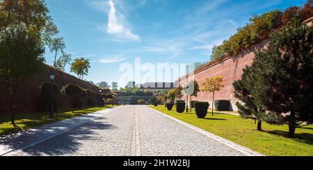 alba-iulia, roumanie - OCT 13, 2019: Les rues intérieures de la citadelle de la Caroline de l'Alba en automne. Les lanternes et les bancs près de la passerelle. Les immenses murs autour du chemin. Banque D'Images