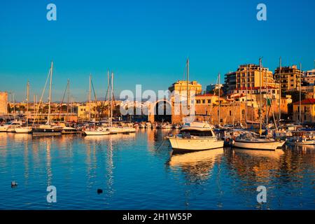 Château du fort vénitien d'Héraklion et bateaux de pêche amarrés, île de Crète, Grèce au coucher du soleil Banque D'Images