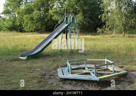 Aire de jeux pour enfants. Des balançoires et un toboggan pour glisser. Banque D'Images