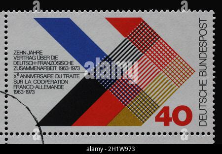 Un timbre imprimé en Allemagne dédié au 10e anniversaire de la collaboration germano-française 1963-1973 croisant les drapeaux de deux pays, vers 1 Banque D'Images