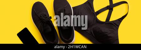 Flat lay top View SPORTSWEAR et smartphone sur fond jaune Banque D'Images