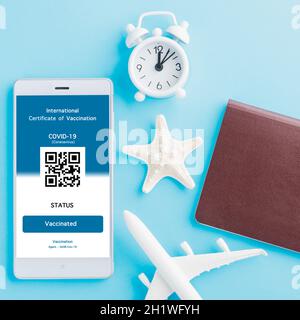 Modèle d'avion, passeport et carte d'immunité sont arrangés application sur smartphone sur fond bleu, Travel concept pendant Covid-19 pandémie numérique Banque D'Images