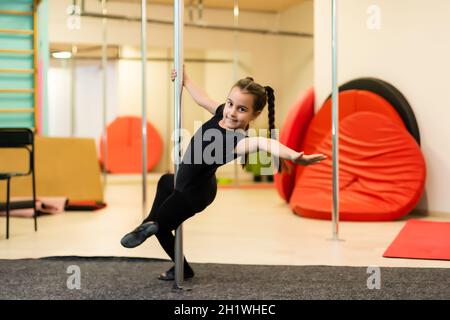 Junior acrobat sur pylône dans la salle de gym Banque D'Images