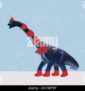 Collage d'art contemporain de dinosaures portant un foulard rouge, un chapeau et des bottes marchant sur la neige sous des flocons de neige Banque D'Images