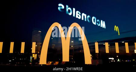 Ukraine, Kiev - 23 août 2019: Vue de la véranda du restaurant McDonalds. Verre avec un logo près de la route la nuit. Banque D'Images