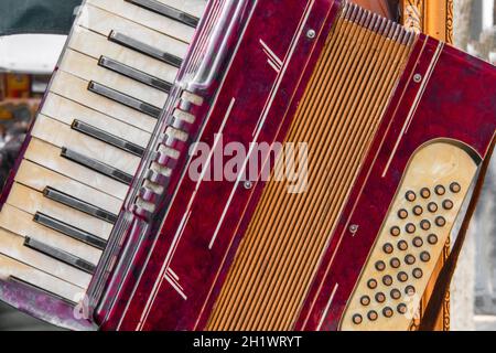 Vue partielle d'un vieux accordéon rouge avec clavier musical et boutons Banque D'Images