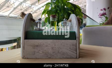 Une table dans un café ou un restaurant. Serviettes dans un porte-serviette en bois, sel et poivre d'épices, huile d'olive et sauce sur la table Banque D'Images