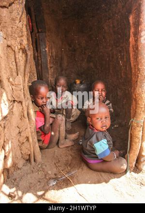 Inconnu Masai village près de parc Amboselli, Kenya - 02 avril, 2015 : Groupe de pauvres enfants sale avec des visages et la bouche couverte de mouches assis à ent Banque D'Images