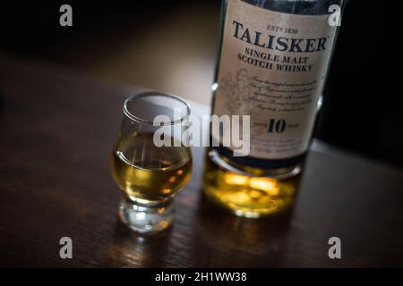 Bucarest, Roumanie - 5 août 2021 : image éditoriale d'une bouteille de whisky Talisker single malt à côté d'un verre sur un comptoir dans un pub. Banque D'Images