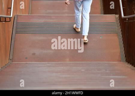 Eine Frau in sommerlicher Kleidung geht auf einer rostigen Stiege aus Stahl hinunter, Österreich, europa - Une femme en vêtements d'été descend une rouille Banque D'Images