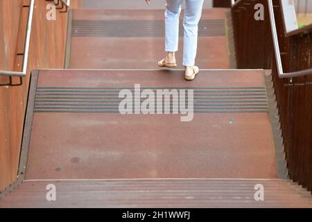 Eine Frau in sommerlicher Kleidung geht auf einer rostigen Stiege aus Stahl hinunter, Österreich, europa - Une femme en vêtements d'été descend une rouille Banque D'Images