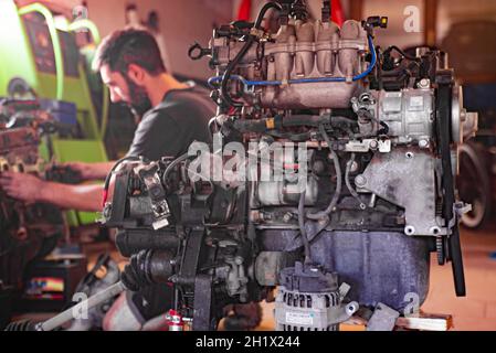 Détail de la révision du moteur de voiture par le mécanicien dans un atelier Banque D'Images