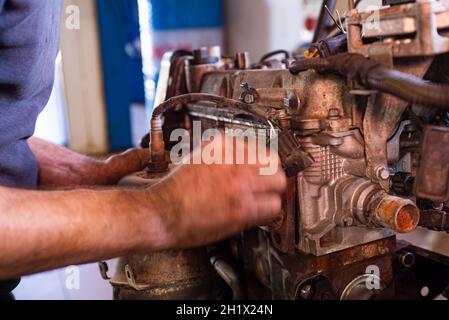 Détail de la révision du moteur de voiture par le mécanicien dans un atelier Banque D'Images