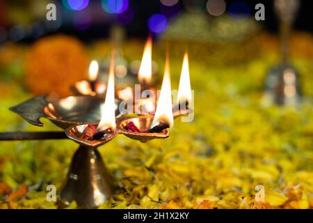 Gros plan de Panchmukhi Diya en laiton doré profondément illuminé sur lit de fleurs Décoration et effet bokeh pour Diwali Puja nouvel an Deepawali ou Shubh Deepawali Banque D'Images