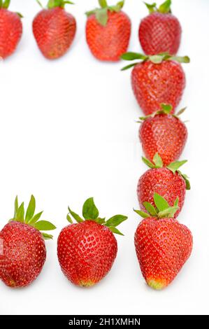 Les fraises les plus sucrées et les plus belles dans les baies rouges, isolées sur fond blanc Banque D'Images