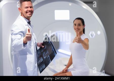Un jeune médecin et une patiente tiennent le pouce dans la salle d'IRM Banque D'Images
