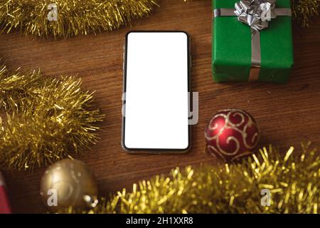 Smartphone avec espace de copie, cadeaux de noël et décorations sur table en bois Banque D'Images