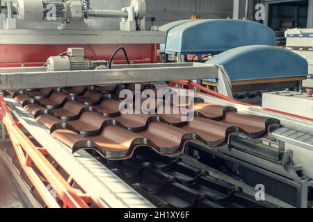 Ligne de production de carreaux métalliques pour le toit.Tapis convoyeur à l'usine de fabrication de métaux. Banque D'Images