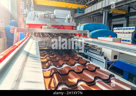 Ligne de production de carreaux métalliques pour le toit.Tapis convoyeur à l'usine de fabrication de métaux. Banque D'Images