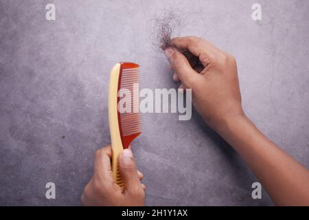 homme tient sa liste de cheveux sur fond noir vue de dessus Banque D'Images