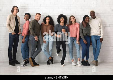 Groupe multiracial de jeunes gens joyeux posant sur le blanc Banque D'Images