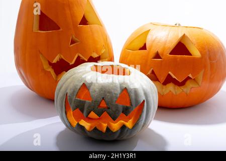 Composition de trois citrouilles sculptées pour halloween avec espace de copie sur fond blanc Banque D'Images