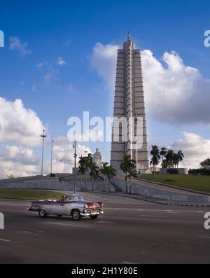 Jose Marti Memorial sur la Plaza de la Revolucion avec le classique américain 1955 Ford Fairlane Sunliner passant dans le ciel bleu et perdu au-dessus.Cuba. Banque D'Images
