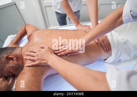 Masser les mains massante l'homme de retour dans le salon de spa Banque D'Images