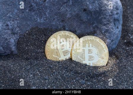 Deux pièces de la monnaie numérique Bitcoin dans le sable Banque D'Images