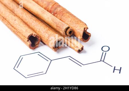 Cannelle aromatique et cinnamaldéhyde, structure chimique et formule. Composé organique qui donne à la cannelle sa saveur et son odeur. Banque D'Images
