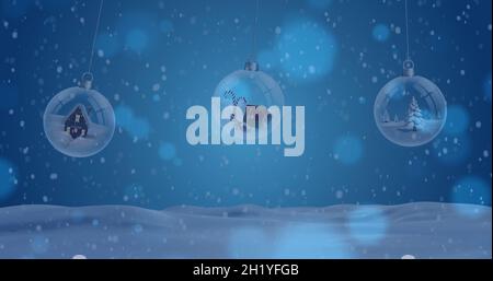 Image de neige tombant sur des boules de noël dans un paysage d'hiver Banque D'Images