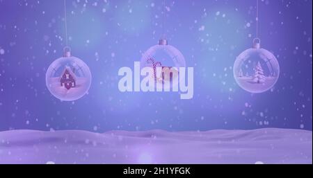 Image de neige tombant sur des boules de noël dans un paysage d'hiver Banque D'Images