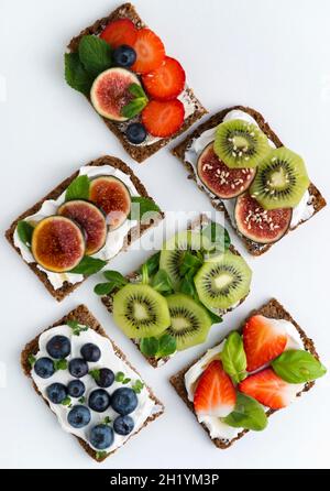 Sandwichs ouverts à base de fromage blanc et de fruits variés Banque D'Images