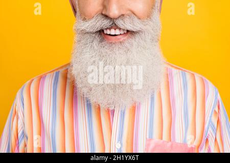 Portrait de vue rognée d'un homme gris aux cheveux bien soignés et gai, isolé sur fond jaune vif Banque D'Images