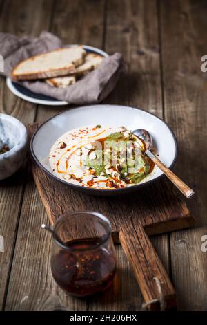 Soupe à l'ail blanc froid avec noix, crème d'épinards et sauce Chili Banque D'Images