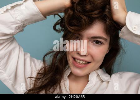 Gros plan portrait de positif attrayant fou joyeux drôle jeune mauriquement brune femme isolée sur fond bleu Banque D'Images