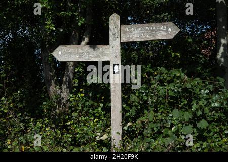 Le panneau en bois du mur d'Hadrien montrant Carlisle est à 2.25 miles et Crosby à 1.75 miles avec le panneau national de l'Acorne de sentier. Banque D'Images