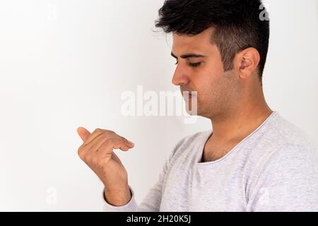 Homme stressé mordant les ongles de doigt sur un arrière-plan isolé. Banque D'Images