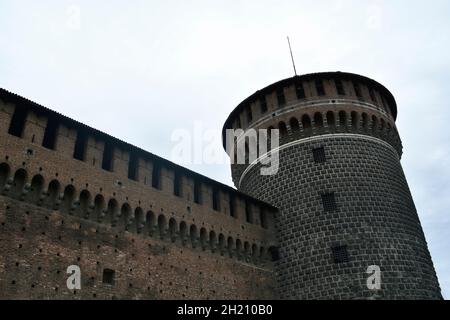 Le mur extérieur du château de Sforza (Castello Sforzesco) et une tour d'angle par un jour sombre. Banque D'Images