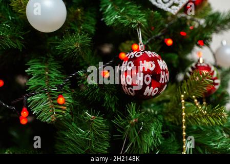 Sapin de Noël artificiel traditionnel avec décoration boule rouge et lumières brillantes Banque D'Images