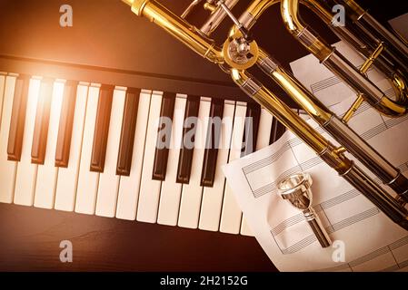 Trombone et piano concert concept avec fond de trombone sur piano et feuilles de personnel vintage.Vue de dessus.Composition horizontale. Banque D'Images