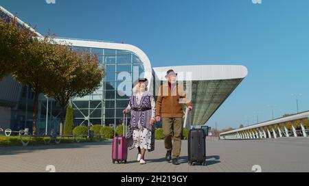 Elégant couple de famille à la retraite grand-père granny marchant avec des valises à bagages à l'entrée de l'aéroport Banque D'Images