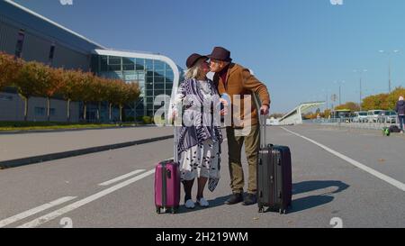 Elégant couple de famille à la retraite grand-père granny marchant avec des valises à bagages à l'entrée de l'aéroport Banque D'Images