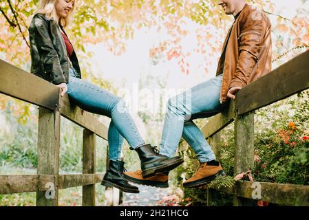 Jeune couple amoureux de s'amuser et de profiter d'une promenade dans le parc d'automne.Concentrez-vous sur les jambes dans les bottes.Mise au point sélective, espace de copie Banque D'Images