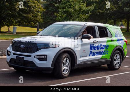 Columbus, OH USA 08-07-2021: Un premier intervenant caucasien attend à l'intérieur d'une voiture paramédique intercepteur Ford dans un parking pendant un événement en plein air. Banque D'Images